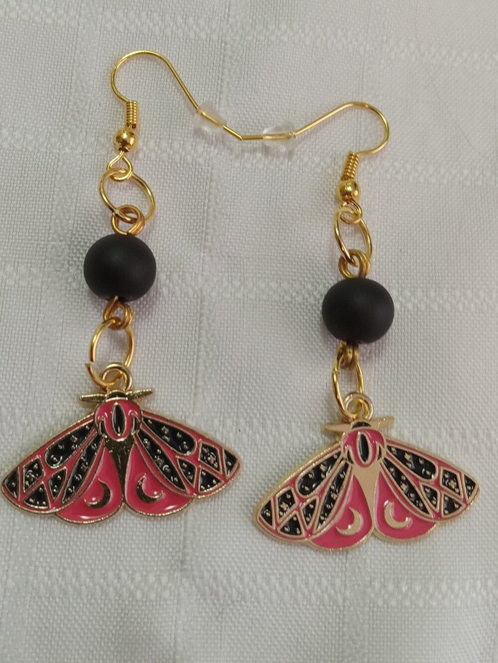Handmade gold-colored earrings with multicolored enameled butterflies and beads